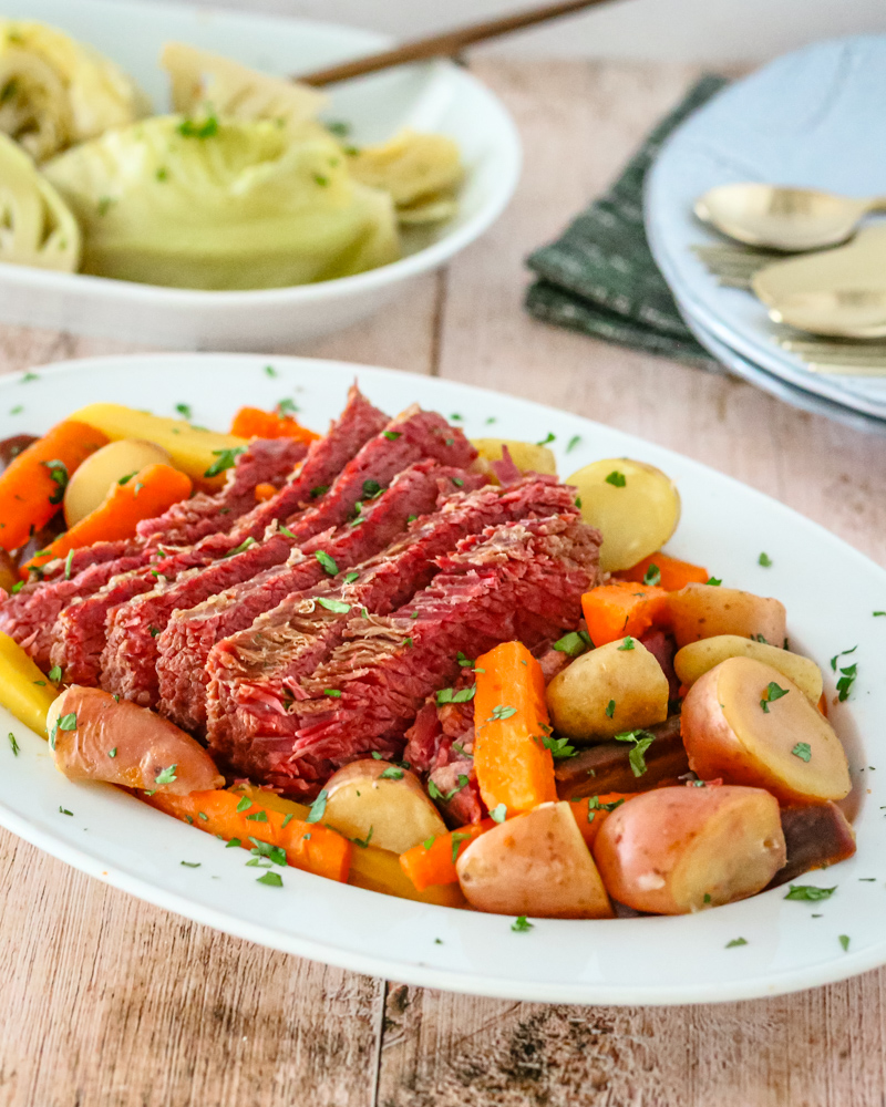 corned beef on a platter with potatoes, carrots, and cabbage on a