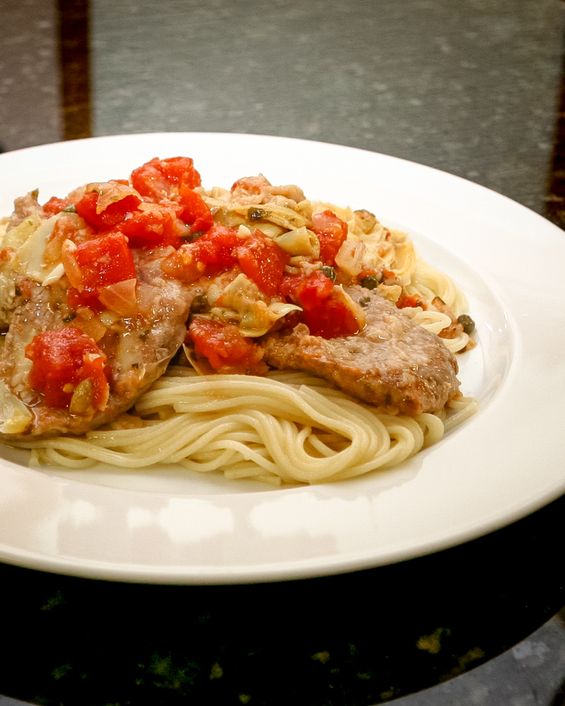 veal cutlets with tomatoes and artichokes on pasta