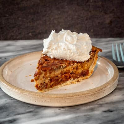 A date pie with whipped cream topping on a plate.