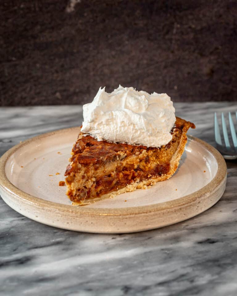 A date pie with whipped cream topping on a plate.