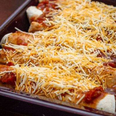 A pan of chicken enchiladas ready to bake