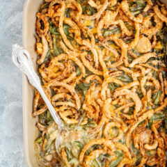 A baking dish with green bean casserole topped with crispy fried onions.