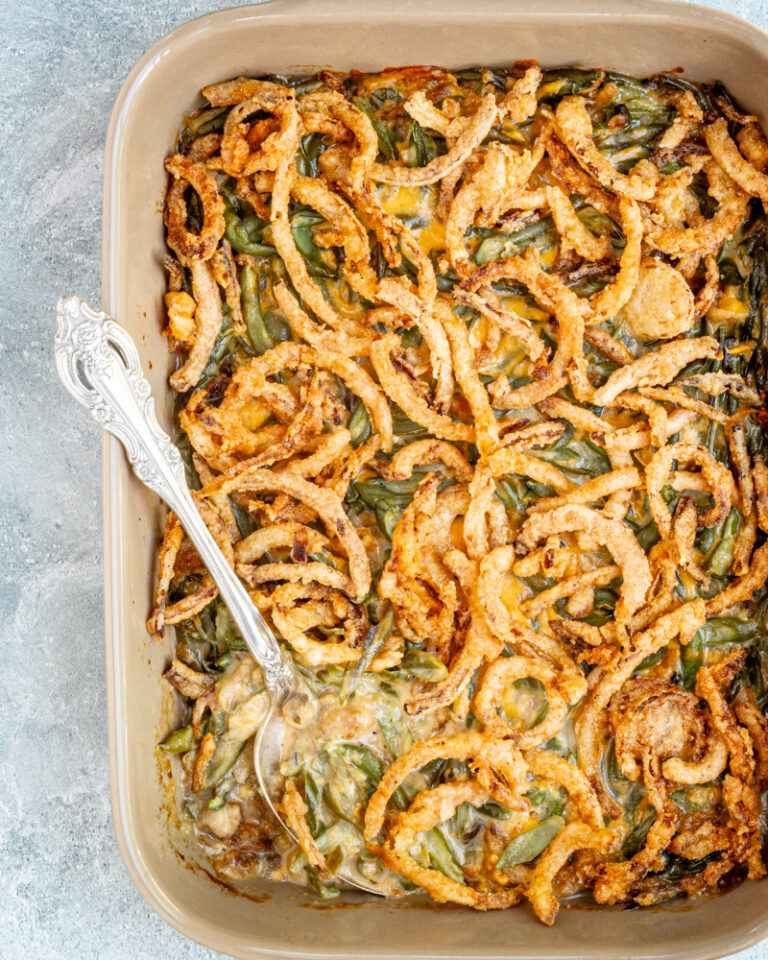 A baking dish with green bean casserole topped with crispy fried onions.