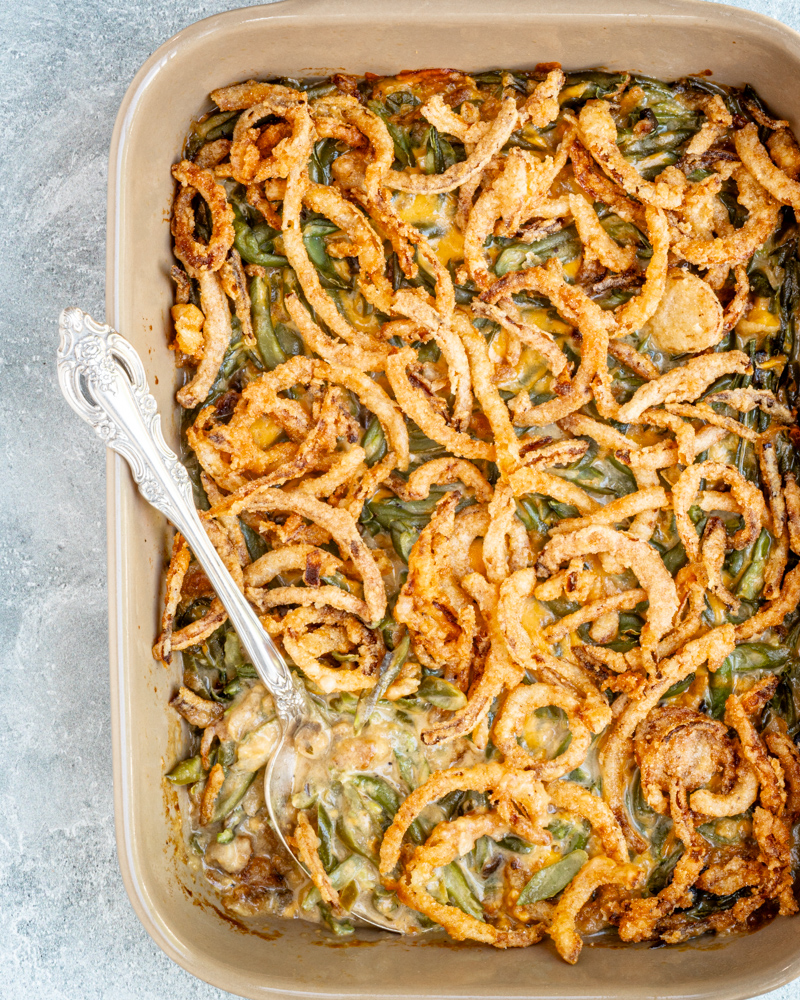 A baking dish with green bean casserole topped with crispy fried onions.