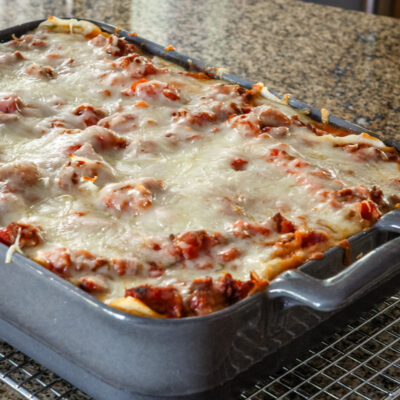 Homemade easy lasagna in a baking dish on a cooling rack.