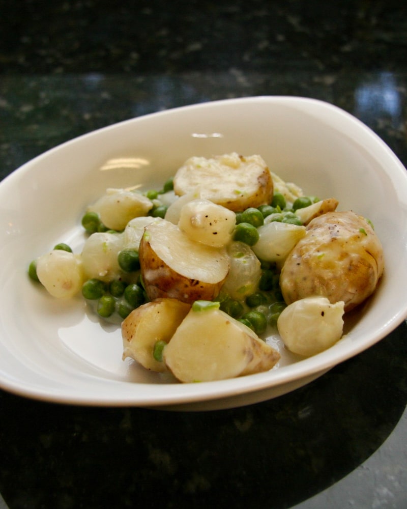 Creamed new potatoes with peas and onions.