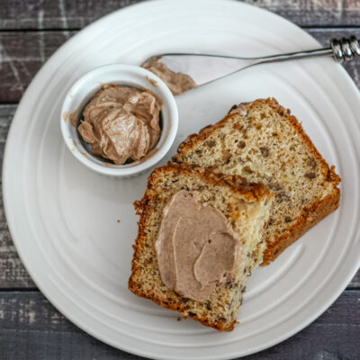 Slices of banana bread with cinnamon butter on the side.