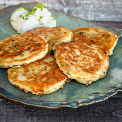 Potato pancakes on a plate with sour cream