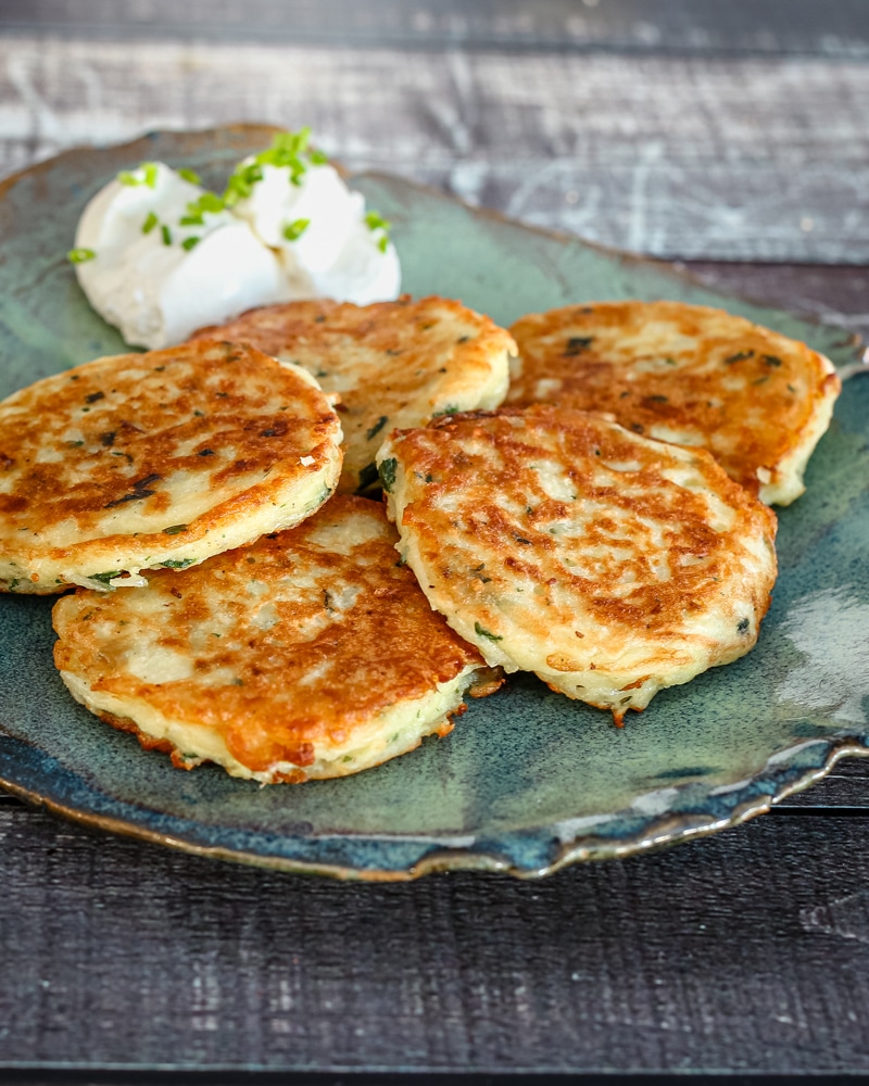 Potato pancakes on a plate with sour cream