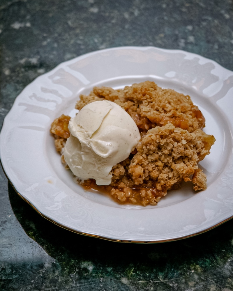 Rhubarb crisp and ice cream on a plate.