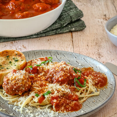 A plate of spaghetti and meatballs on a plate with Parmesan cheese.