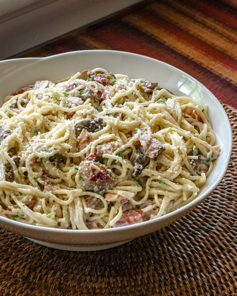 Spaghetti with bacon and mushrooms in a serving bowl