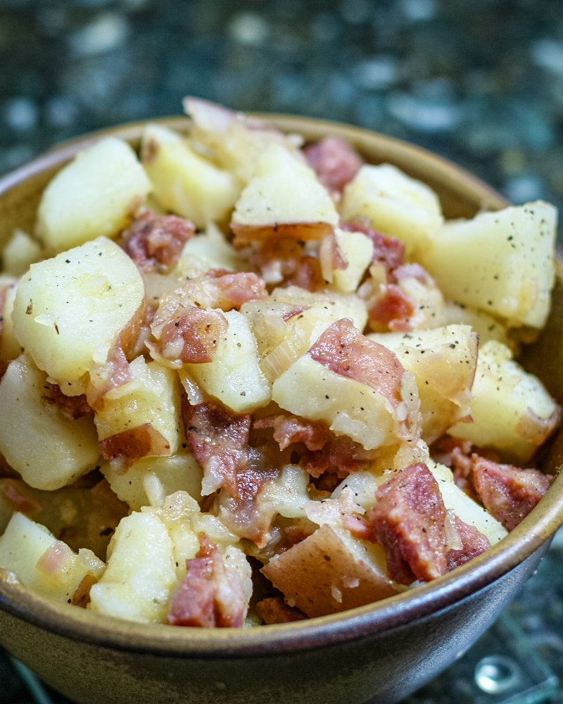 warm potato salad with sausage in a bowl