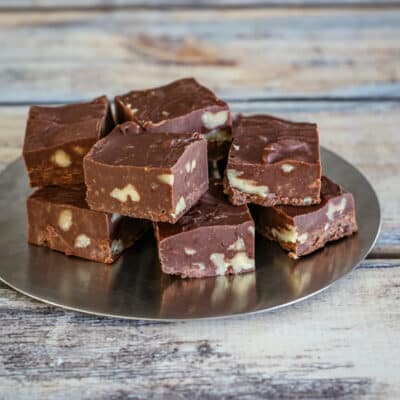 A stack of chocolate fudge on a decorative plate.