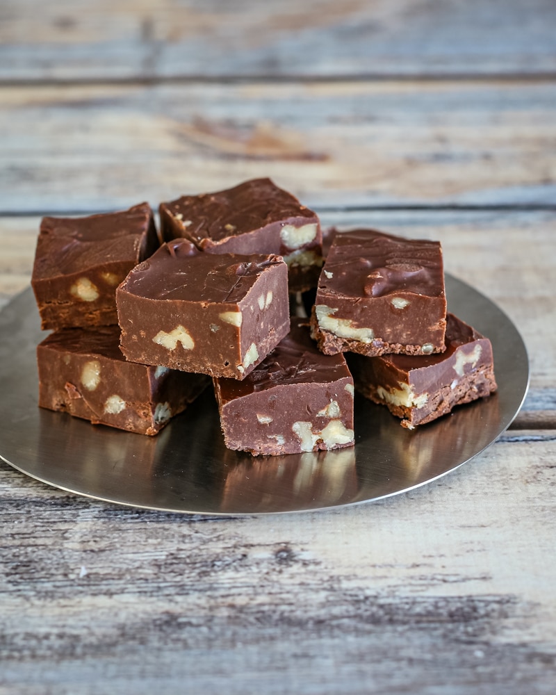 A stack of chocolate fudge on a decorative plate.