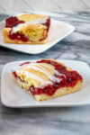 Iced cherry cobbler bars on dessert plates.
