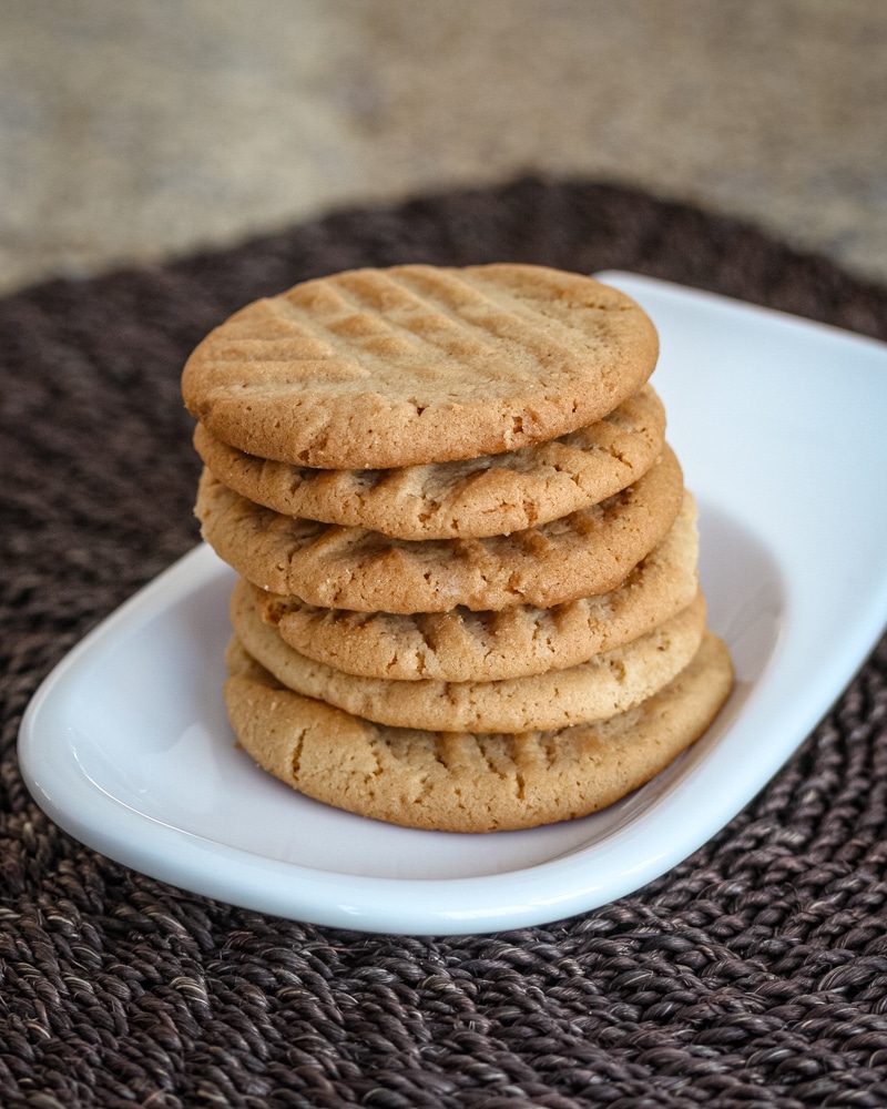A stack of peanut butter cookies on a small plate.