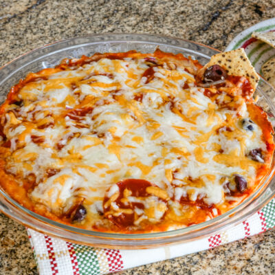 Pepperoni pizza dip baked in a pie plate with chips.