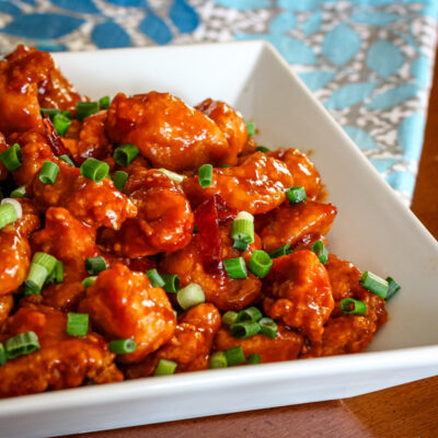 A serving bowl with general tso's chicken.