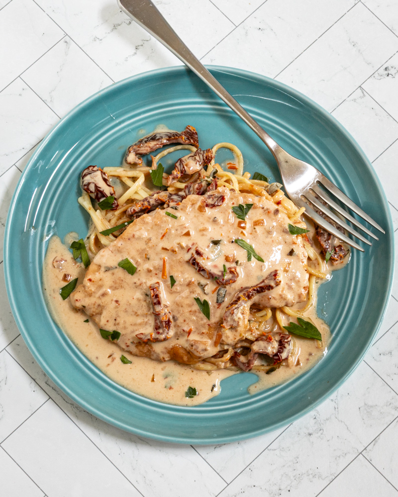 Marry me chicken served on cooked spaghetti with creamy sundried tomato sauce.