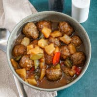 Slow cooker sweet and sour meatballs with bell pepper and pineapple chunks.