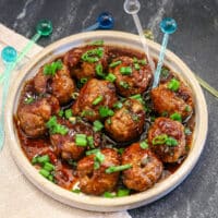 Teriyaki meatballs served as an appetizer with picks and a garnish of green onion tops.