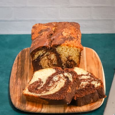 A loaf of marble pound cake on a cutting board.
