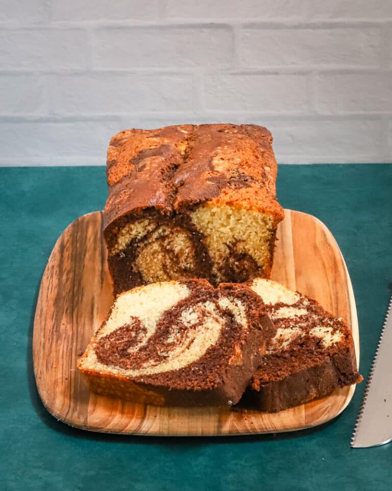 A loaf of marble pound cake on a cutting board.