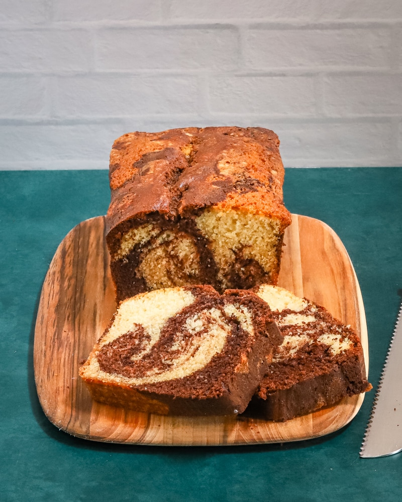 A loaf of marble pound cake on a cutting board.
