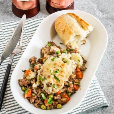 A plated cottage pie cooked in the air fryer with crusty bread on the side.