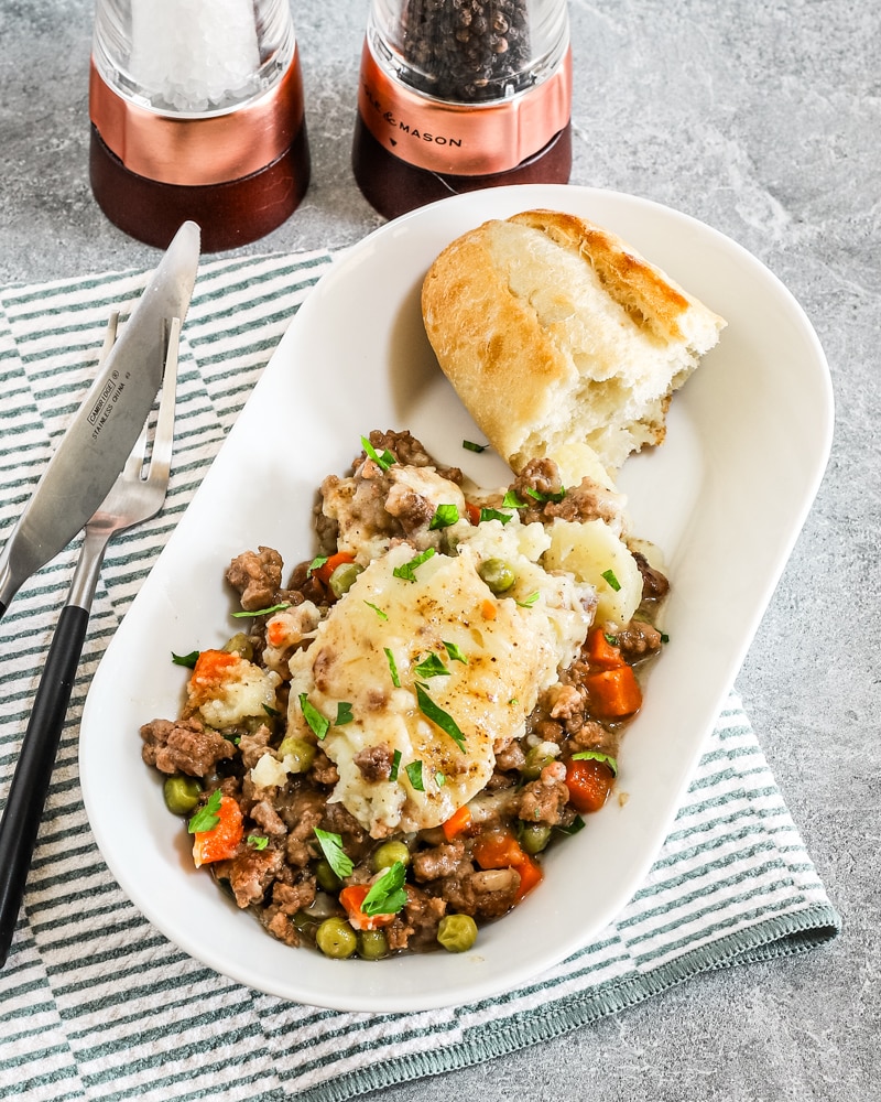A plated cottage pie cooked in the air fryer with crusty bread on the side.