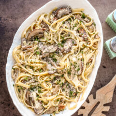 Pasta with duck confit and mushrooms in a serving bowl.