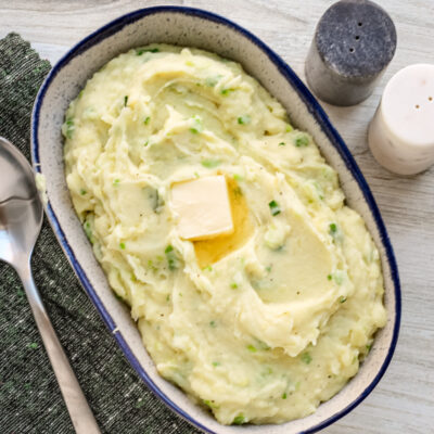 Mashed Irish champ mashed potatoes with scallions and a pat of butter, ready to enjoy.