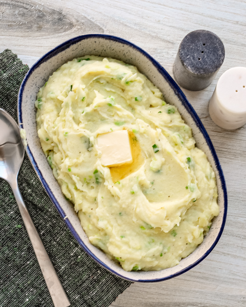 Mashed Irish champ mashed potatoes with scallions and a pat of butter, ready to enjoy.