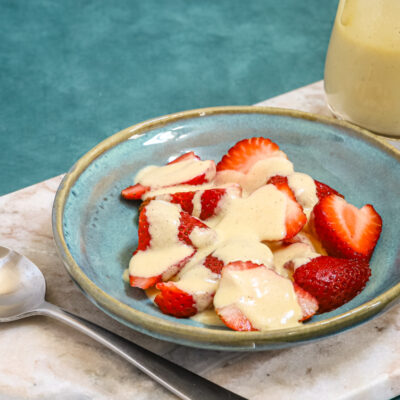 Creme Anglaise on strawberries in a bowl.