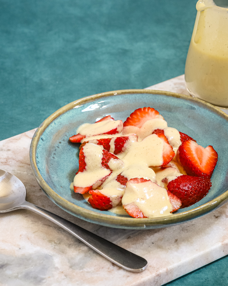Creme Anglaise on strawberries in a bowl.