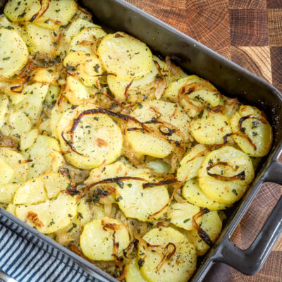 A baking dish with baked lyonnaise potatoes.