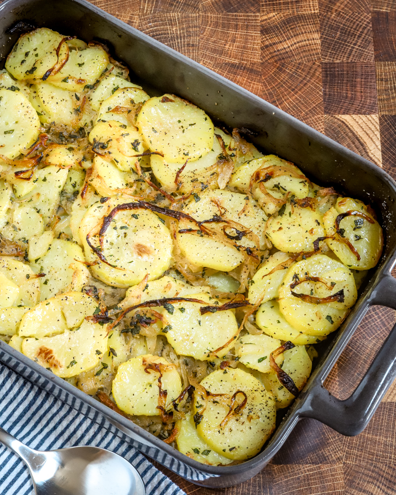 A baking dish with baked lyonnaise potatoes.