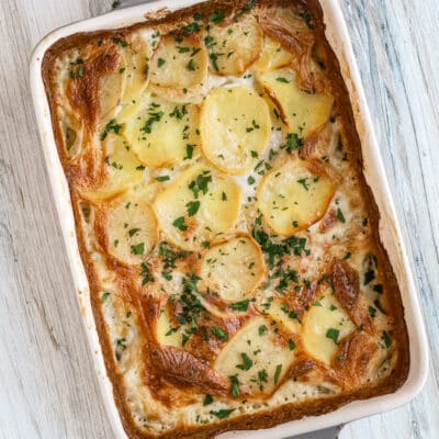 Baked dauphinoise potatoes with parsley garnish - potato gratin.