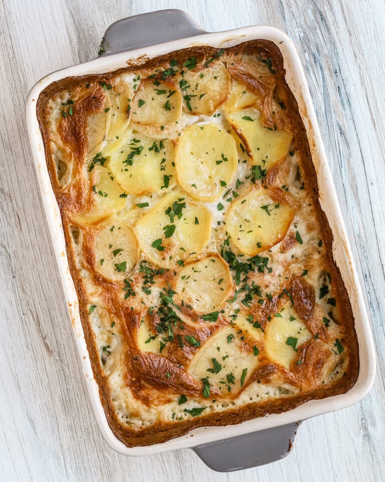 Baked dauphinoise potatoes with parsley garnish - potato gratin.