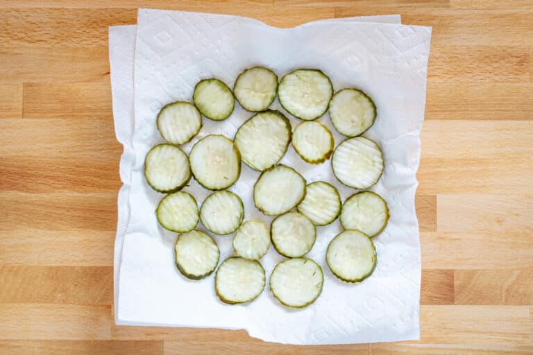 Sliced pickles on paper towel.