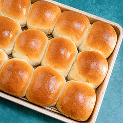 A pan of golden brown baked dinner rolls.