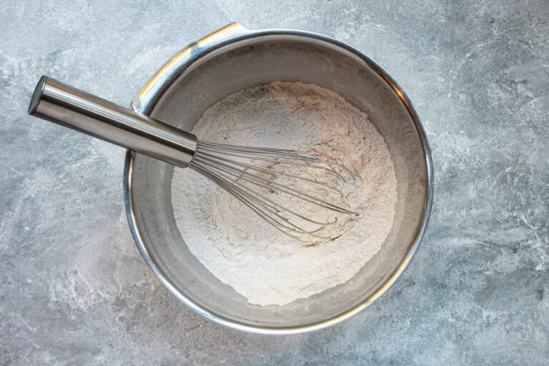 Combining dry ingredients in a bowl for pumpkin fritters.