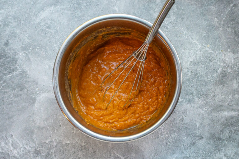 Combining the wet ingredients in a bowl for pumpkin fritters.