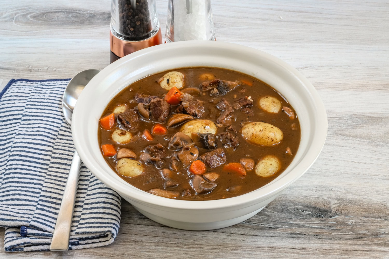 Hearty beef stew with potatoes, carrots, and mushrooms in a rich broth.