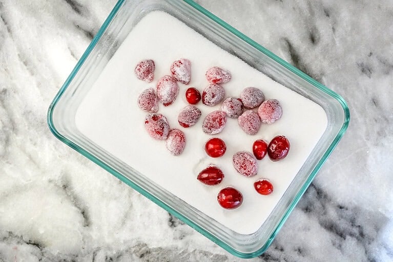 Coating the sticky cranberries with sugar.