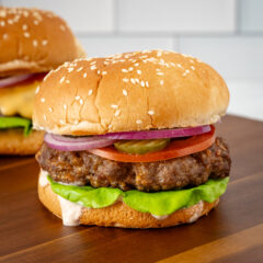 Juicy beef burgers with fresh vegetables and sesame seed buns.