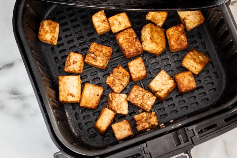 Tofu cubes in the air fryer basket.