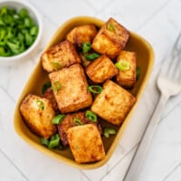 A small dish with air-fried tofu and a garnish of sliced green onions.