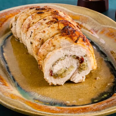 A pork loin roast stuffed with apple and dried cranberries on a Kentucky pottery platter.